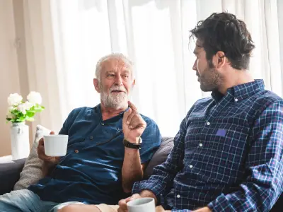 older man and a younger man talking on the couch